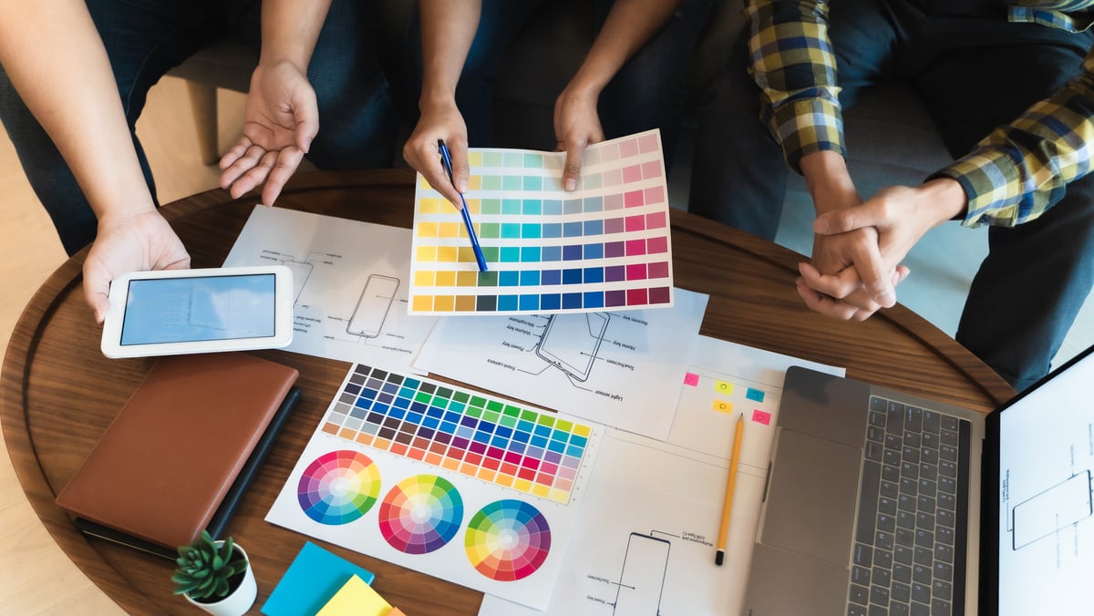 Image of designers choosing colors from a color wheel. 