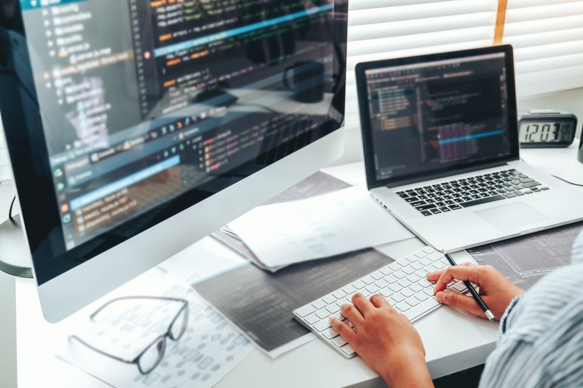 Image of a desk with a computer screen. On the is  programing code.